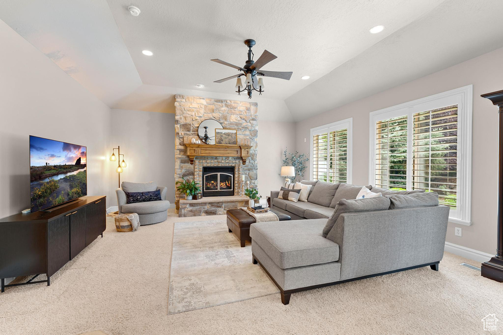 Carpeted living room with ceiling fan, lofted ceiling, a fireplace, and recessed lighting