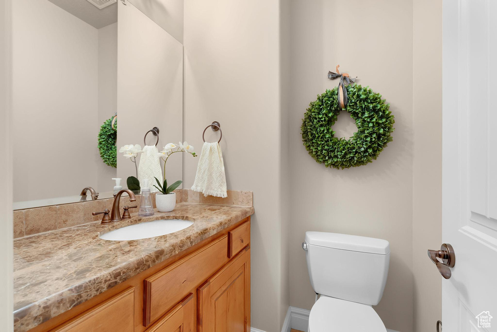 Half bathroom featuring vanity and toilet