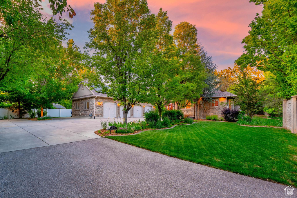 Obstructed view of property with stone siding and driveway