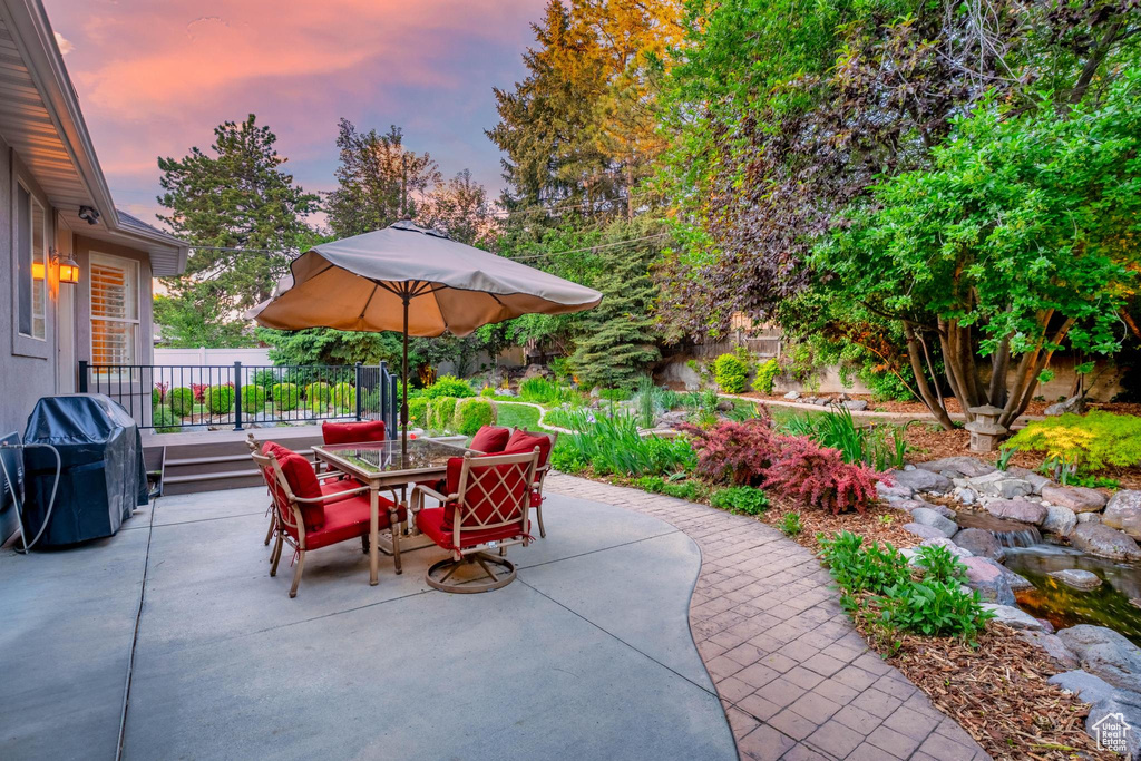 Patio terrace at dusk featuring outdoor dining space, a patio area, and area for grilling