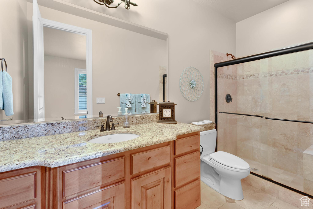 Full bath featuring vanity, a shower stall, toilet, and tile patterned floors