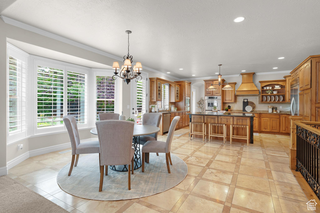 Dining room with inlaid floor details, a chandelier, recessed lighting, and crown molding