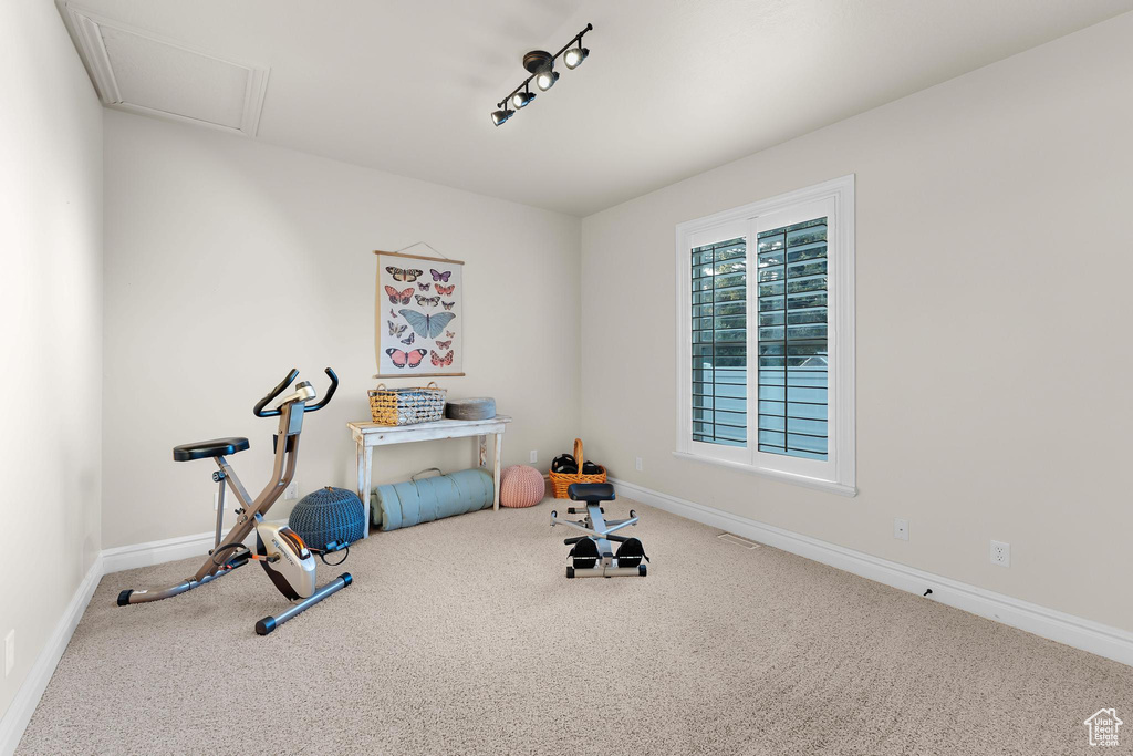Exercise area with carpet floors and baseboards