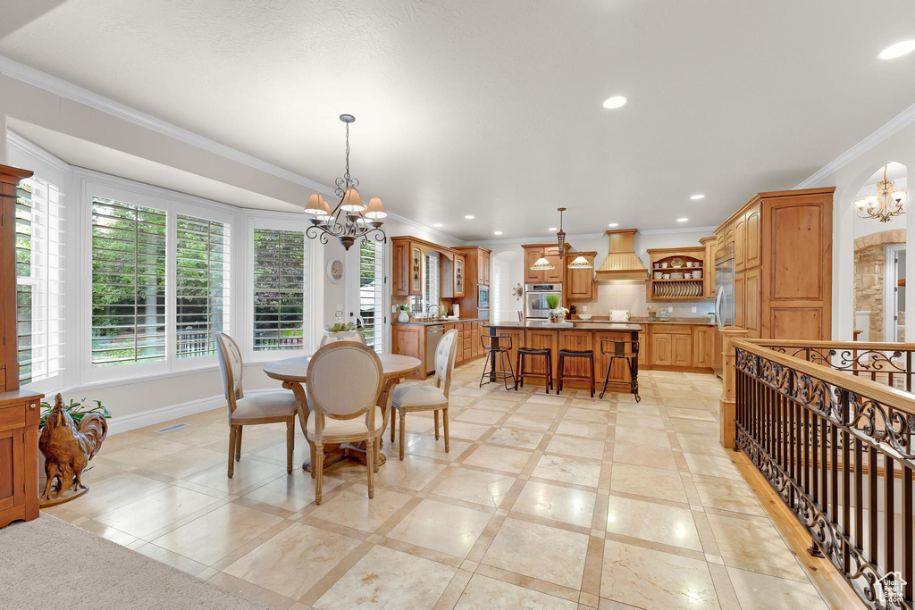 Dining space featuring a chandelier, crown molding, recessed lighting, baseboards, and inlaid floor details