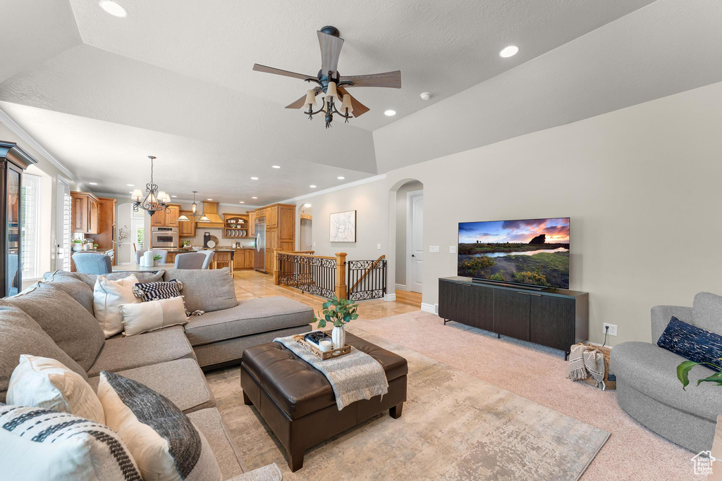 Living room featuring recessed lighting, ceiling fan, arched walkways, a chandelier, and crown molding