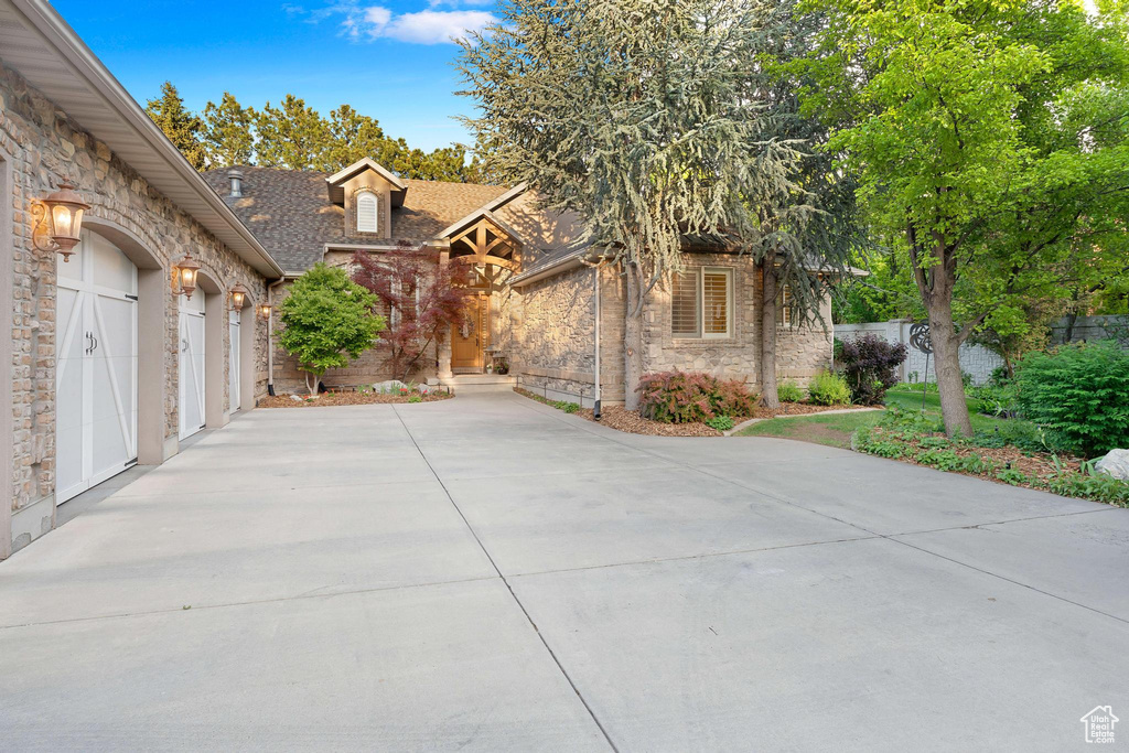 View of front of property featuring stone siding and concrete driveway
