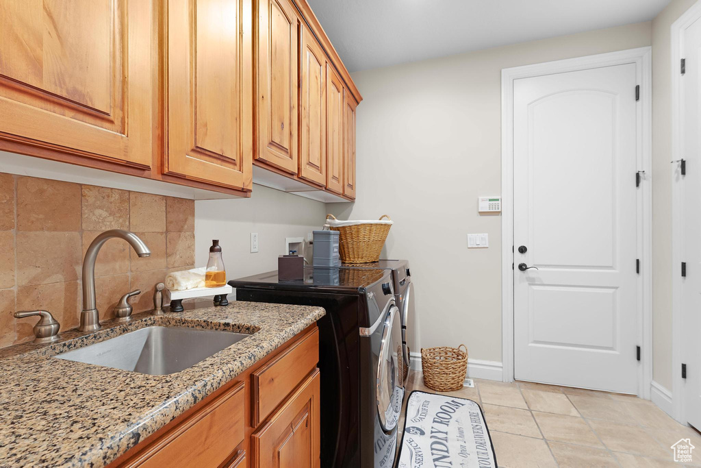 Laundry area featuring cabinet space, independent washer and dryer, baseboards, and light tile patterned floors