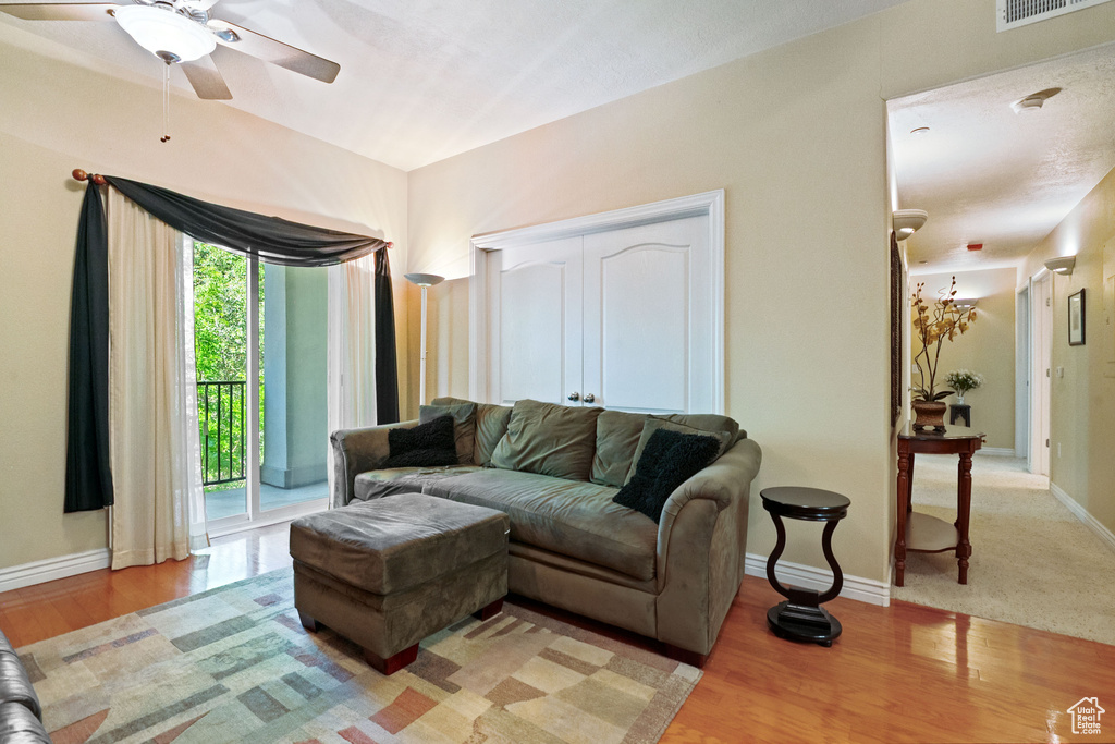 Living area featuring ceiling fan, light wood finished floors, and baseboards