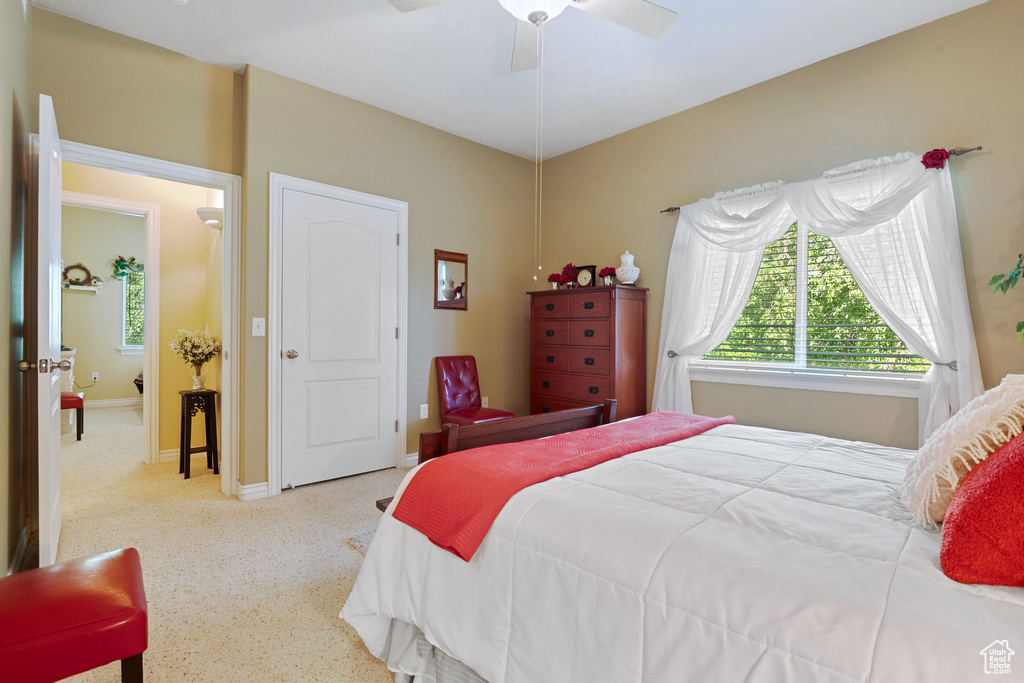 Carpeted bedroom with ceiling fan and baseboards