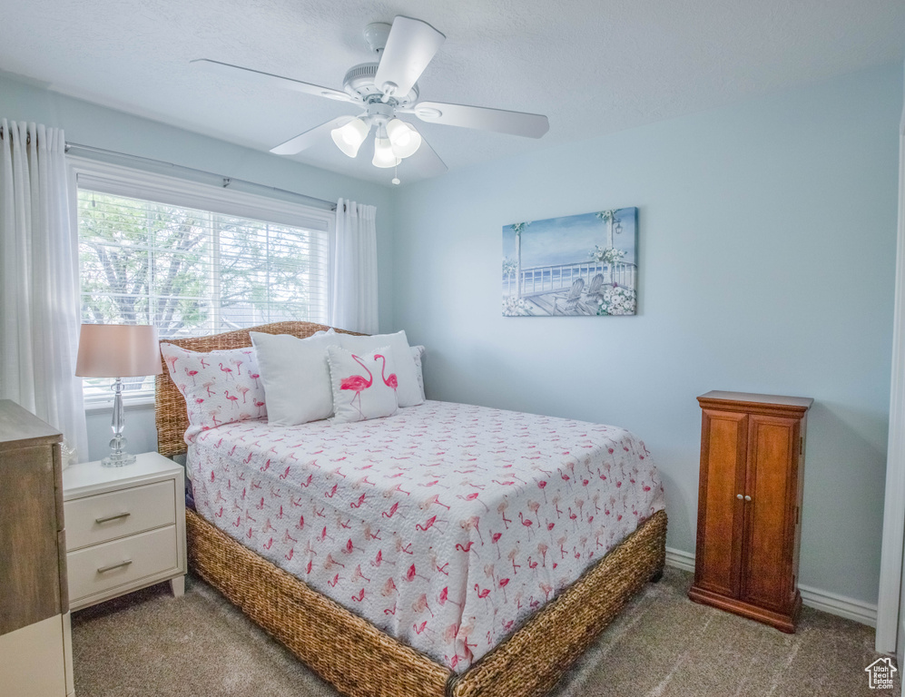 Carpeted bedroom featuring a ceiling fan