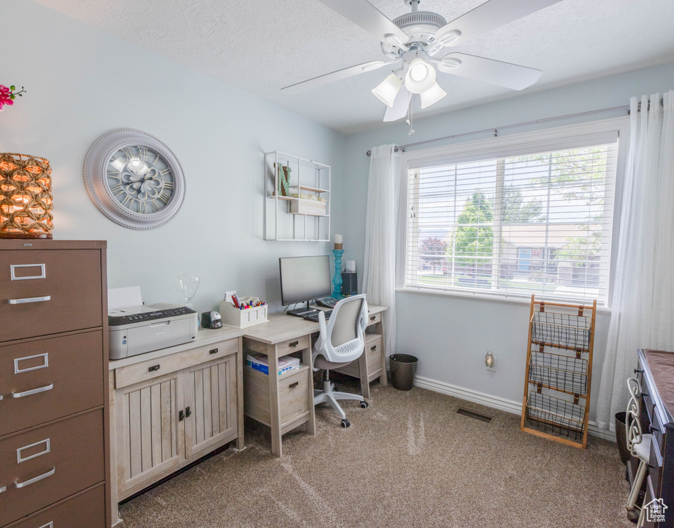 Office space with a ceiling fan, light carpet, and baseboards