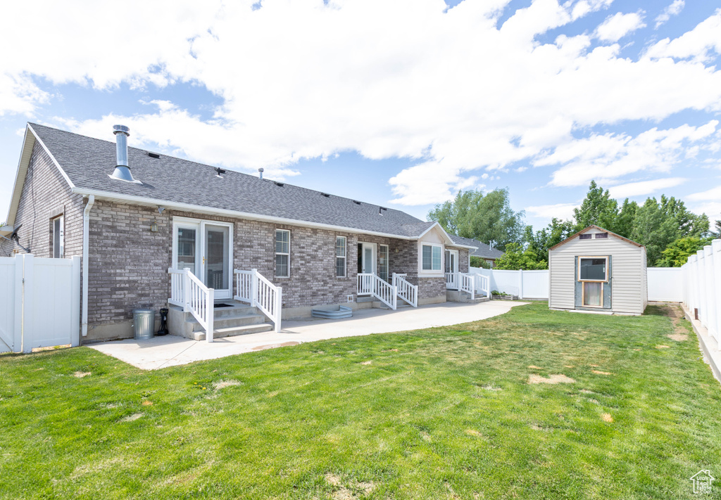 Back of house with a patio area, a shingled roof, and brick siding