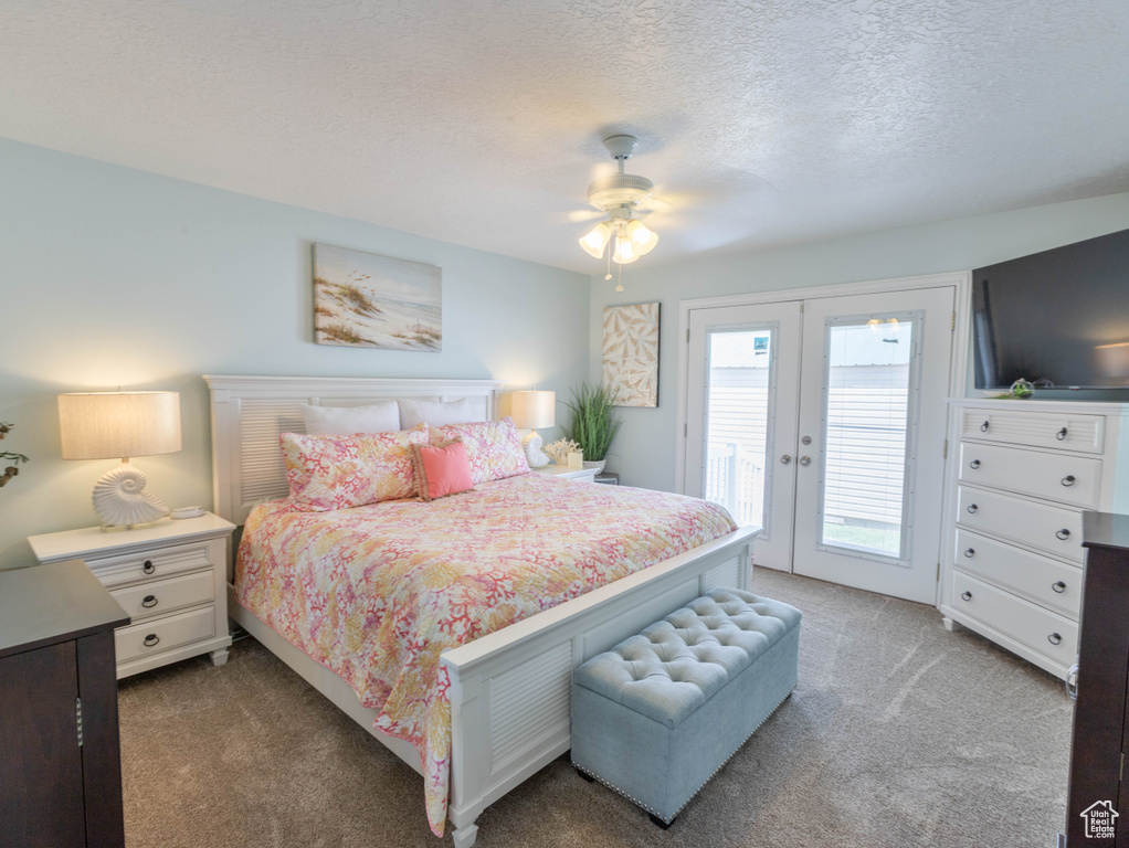 Carpeted bedroom with access to exterior, a textured ceiling, and ceiling fan