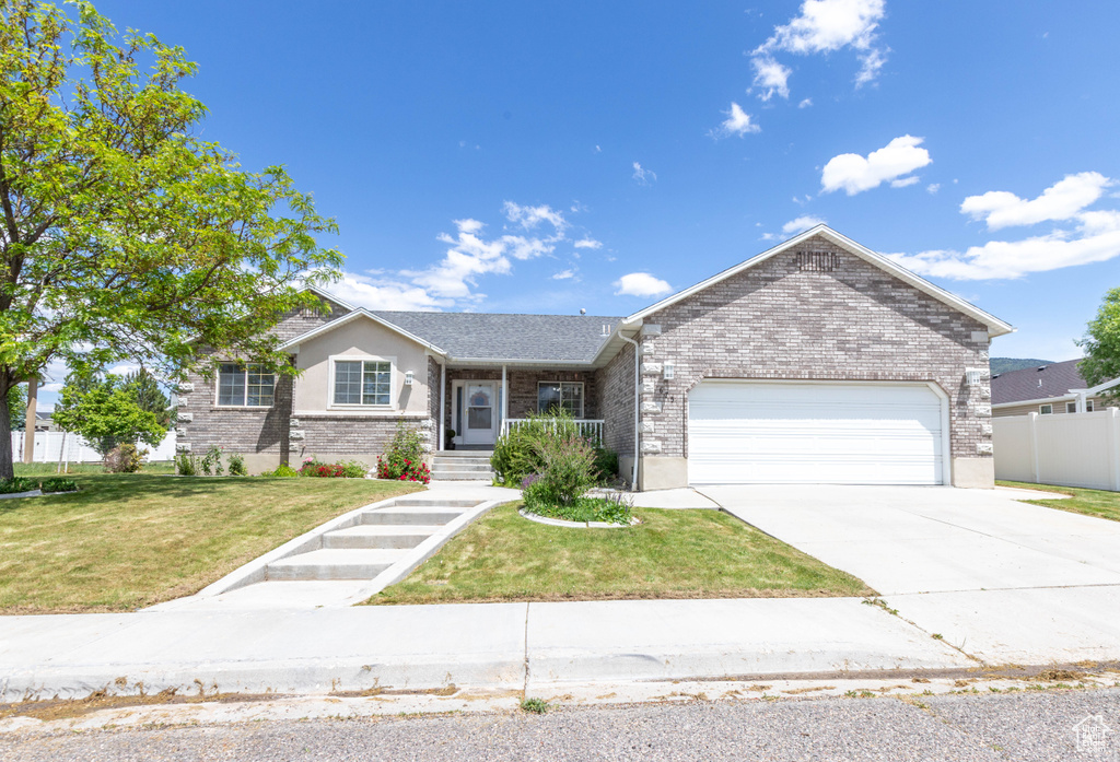 Single story home with brick siding, a garage, and concrete driveway