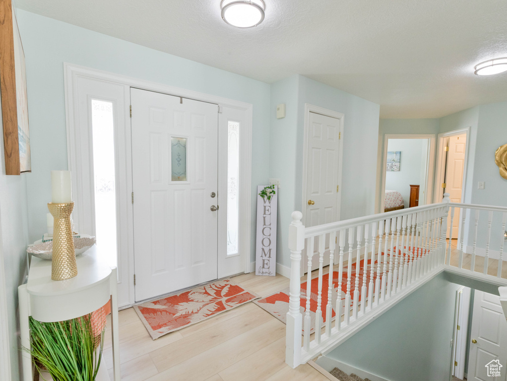 Foyer entrance with wood finished floors and healthy amount of natural light
