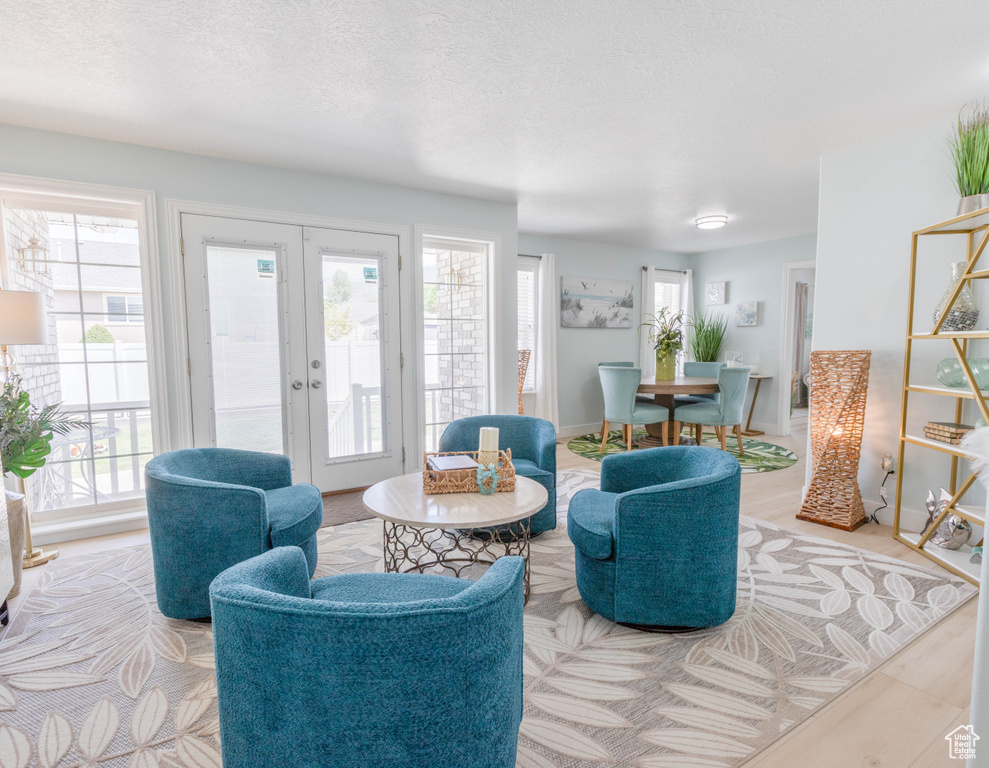 Living area featuring french doors, healthy amount of natural light, and a textured ceiling