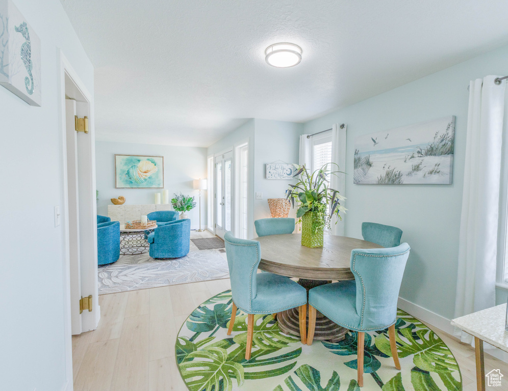 Dining area with light wood-style floors, french doors, and baseboards