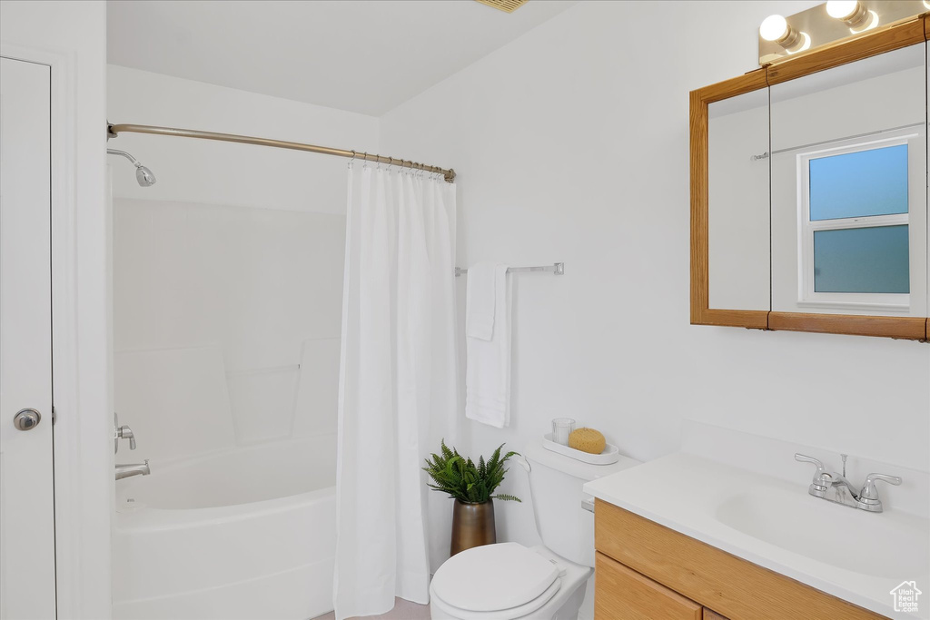 Bathroom with shower / bath combo, vanity, and toilet
