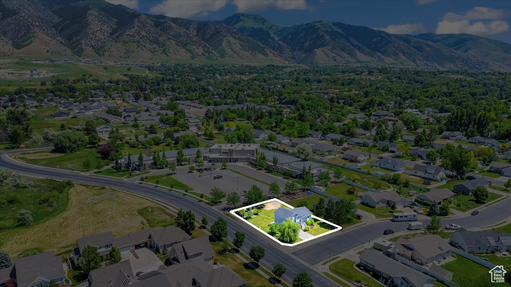 Aerial view of residential area featuring property boundaries highlighted and a mountainous background