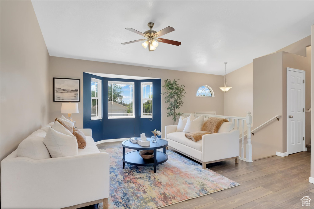 Living room featuring a ceiling fan, wood finished floors, and baseboards