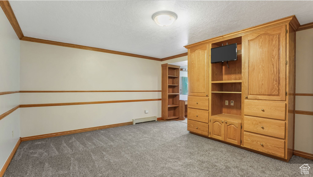 Unfurnished bedroom featuring baseboard heating, light carpet, baseboards, ornamental molding, and a textured ceiling