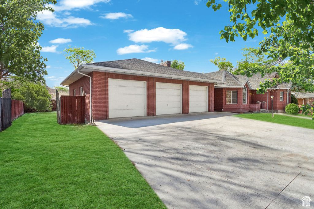 Single story home with an attached garage, brick siding, driveway, and a chimney