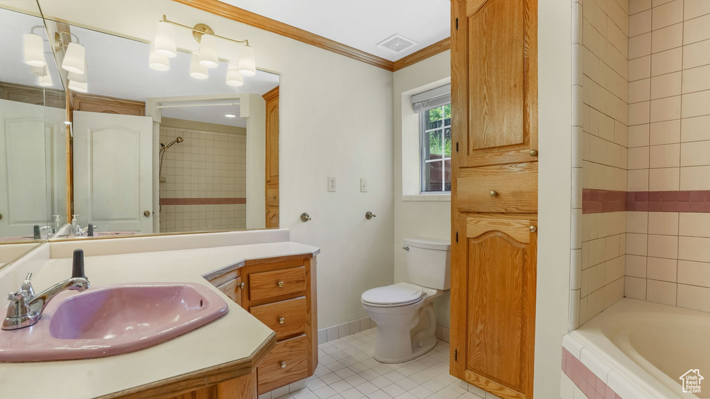 Bathroom with toilet, vanity, tile patterned flooring, and crown molding