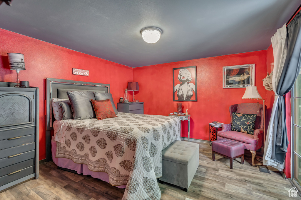 Bedroom with wood finished floors and baseboards