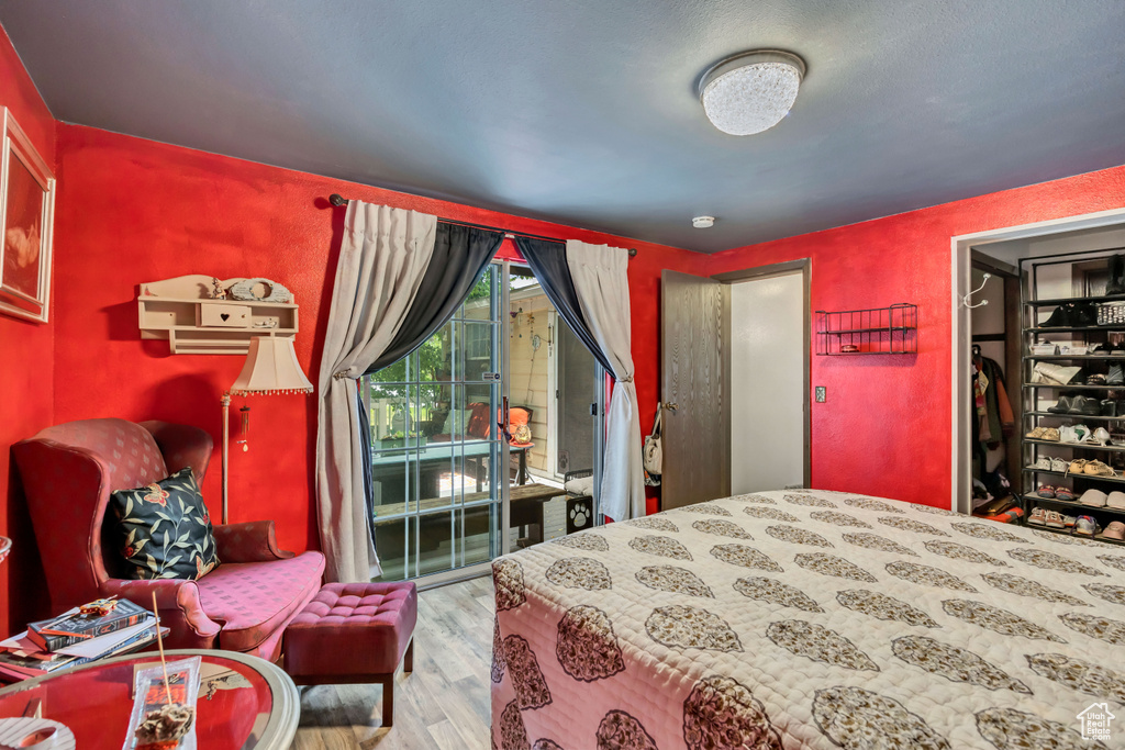 Bedroom with wood finished floors and access to outside