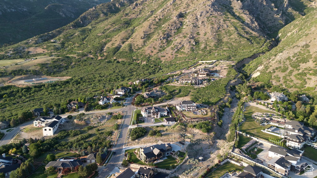 Aerial view of property and surrounding area featuring nearby suburban area and a mountain backdrop