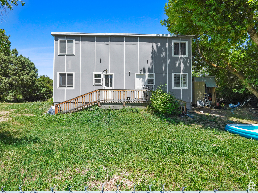 Back of property with a lawn and a deck