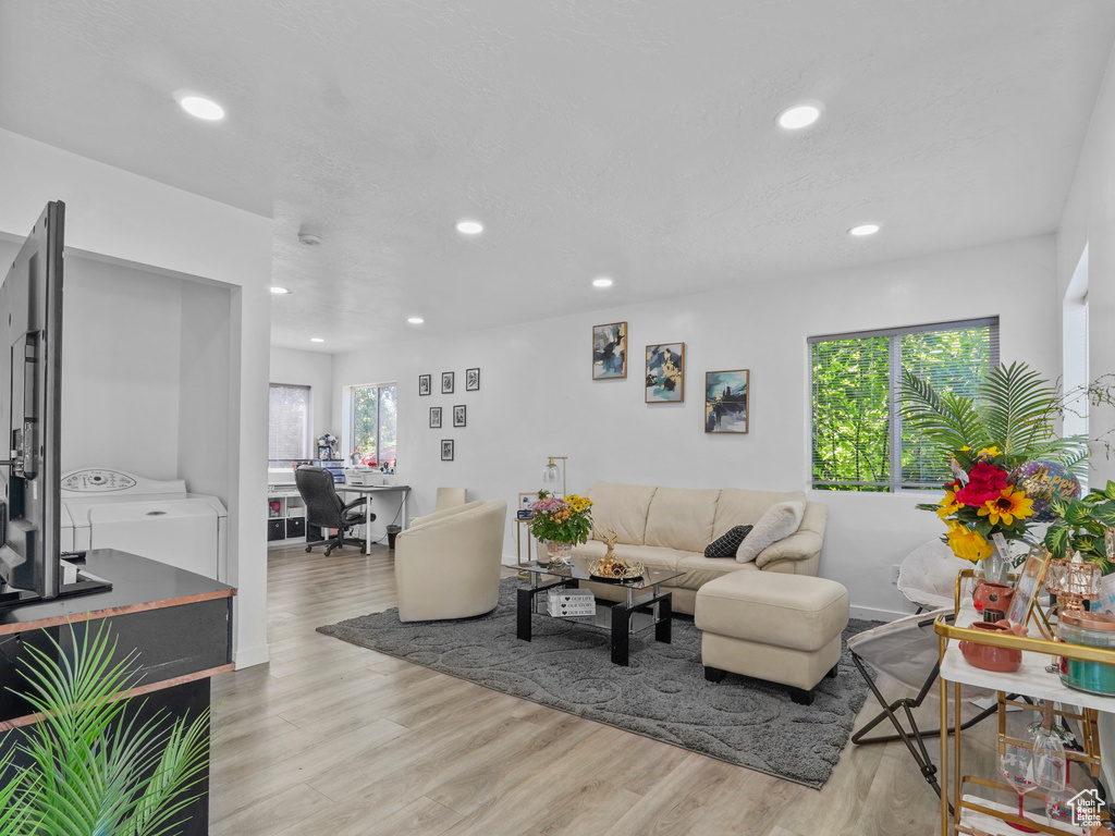 Living room with separate washer and dryer, recessed lighting, wood finished floors, and baseboards