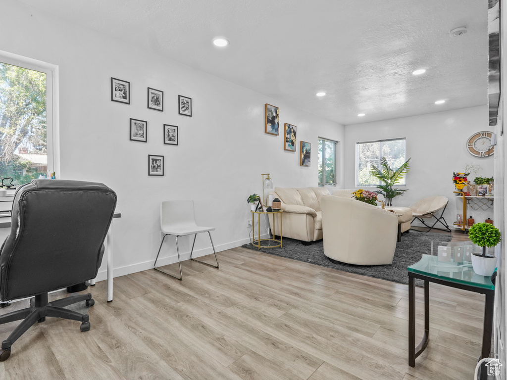 Living area with wood finished floors, recessed lighting, and baseboards