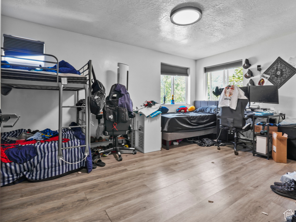 Bedroom with a textured ceiling and wood finished floors