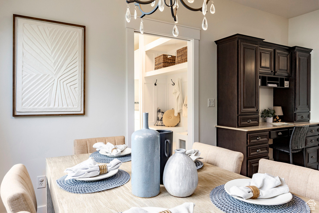 Dining space featuring a chandelier and a desk