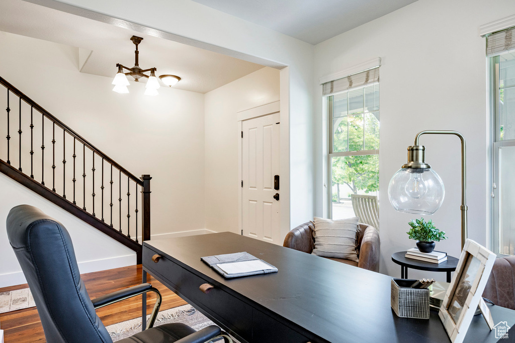 Office area with a chandelier, wood finished floors, and baseboards