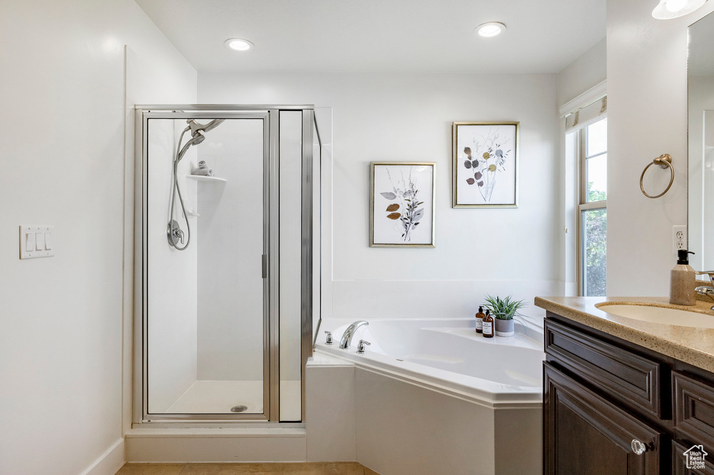 Bathroom with vanity, a garden tub, a stall shower, and recessed lighting