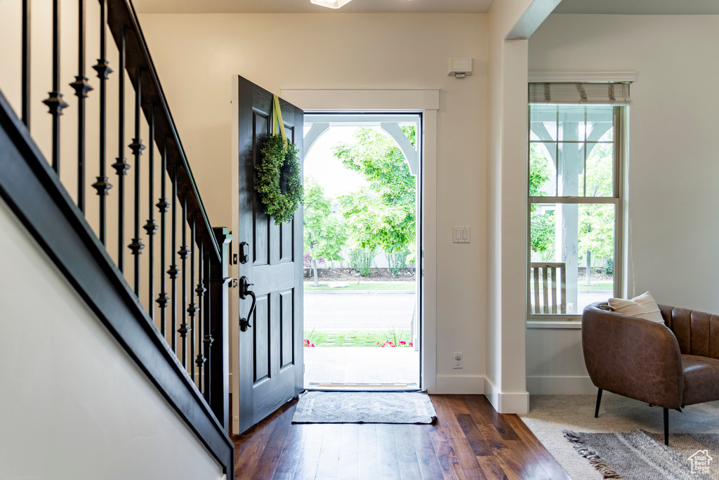 Entryway featuring healthy amount of natural light, wood-type flooring, baseboards, and stairs