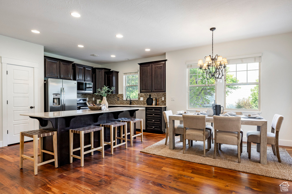 Kitchen with appliances with stainless steel finishes, a chandelier, dark wood-style floors, a sink, and recessed lighting