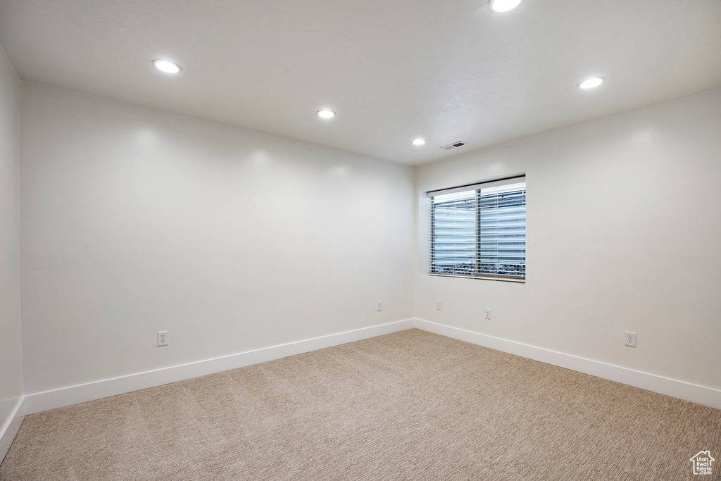 Unfurnished room featuring light colored carpet, recessed lighting, and baseboards