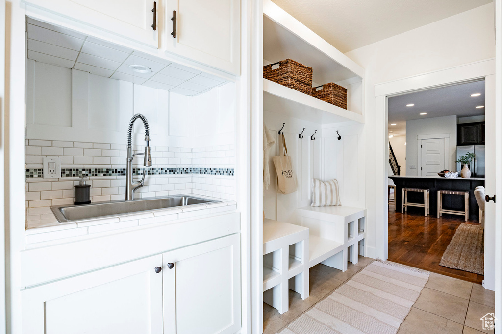 Mudroom with a sink, light tile patterned floors, and recessed lighting