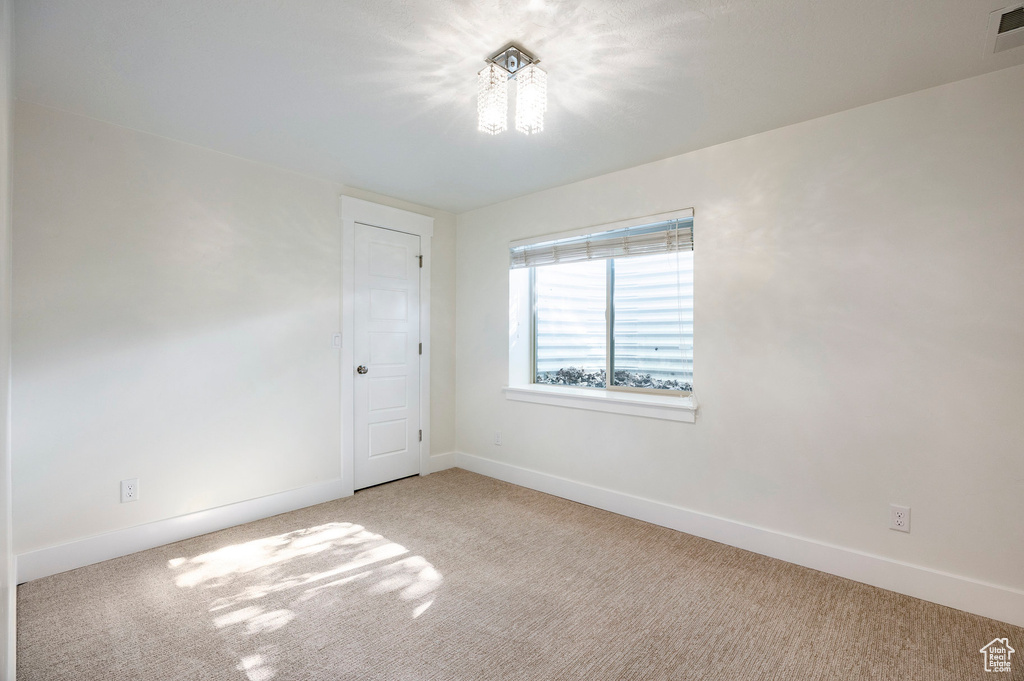 Carpeted spare room with baseboards