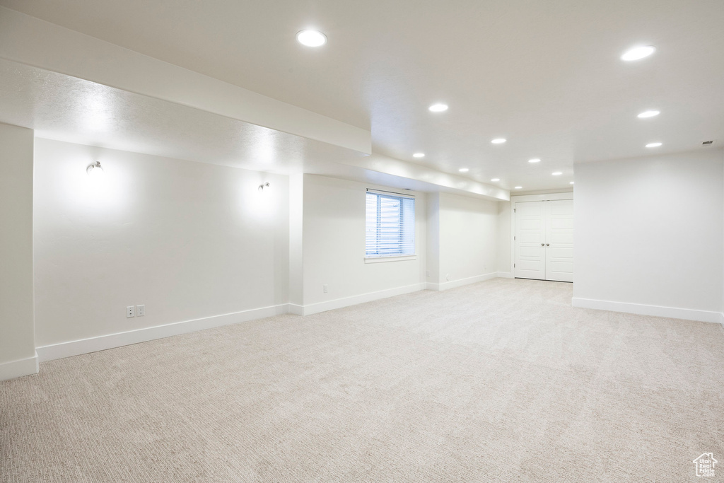 Below grade area with light carpet, baseboards, and recessed lighting