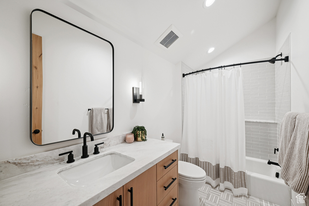Full bathroom with vanity, toilet, vaulted ceiling, shower / bath combo with shower curtain, and recessed lighting