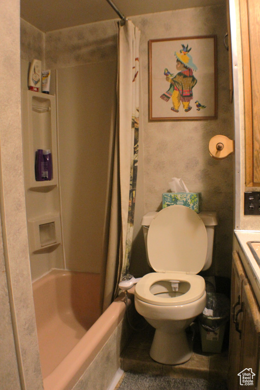 Bathroom with toilet, vanity, and shower / bath combo with shower curtain