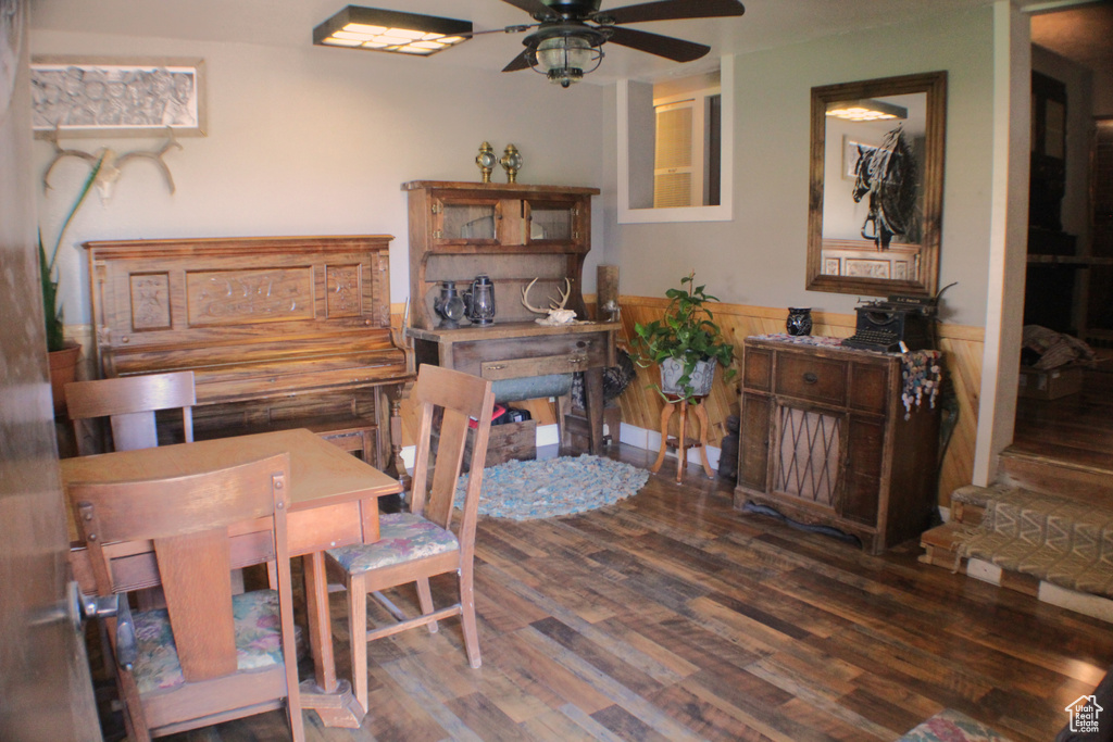 Dining room featuring a wainscoted wall, wood finished floors, and a ceiling fan