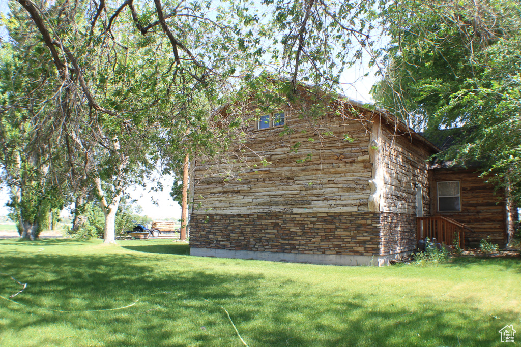 View of property exterior with a yard