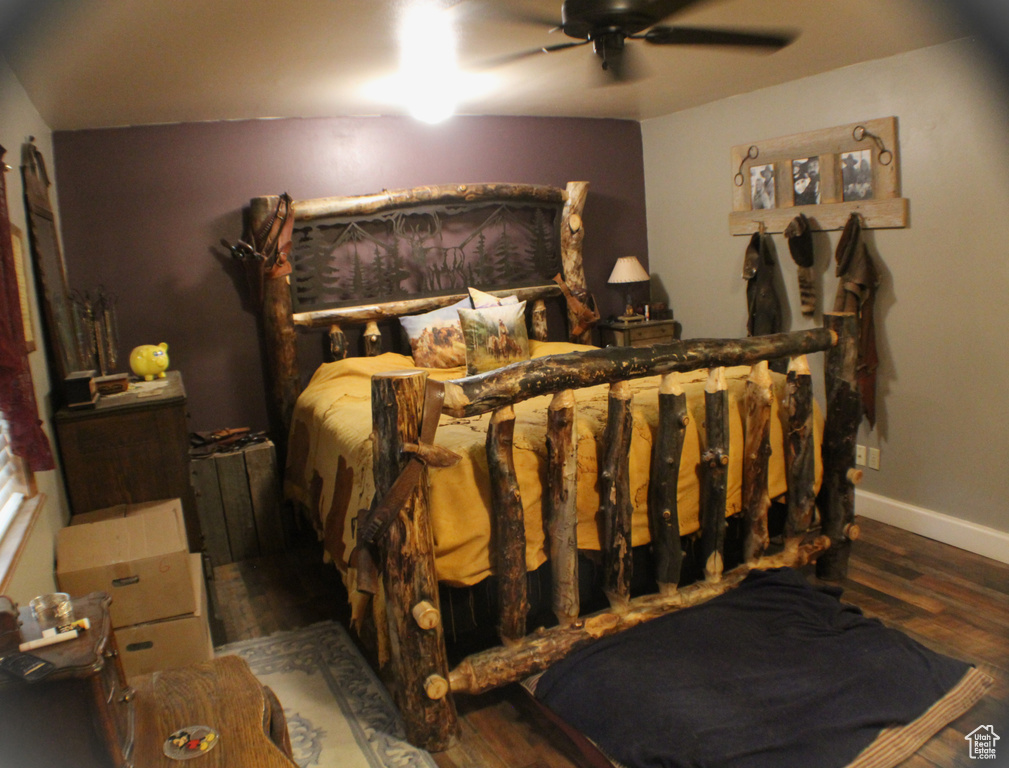 Bedroom featuring wood finished floors, baseboards, and a ceiling fan