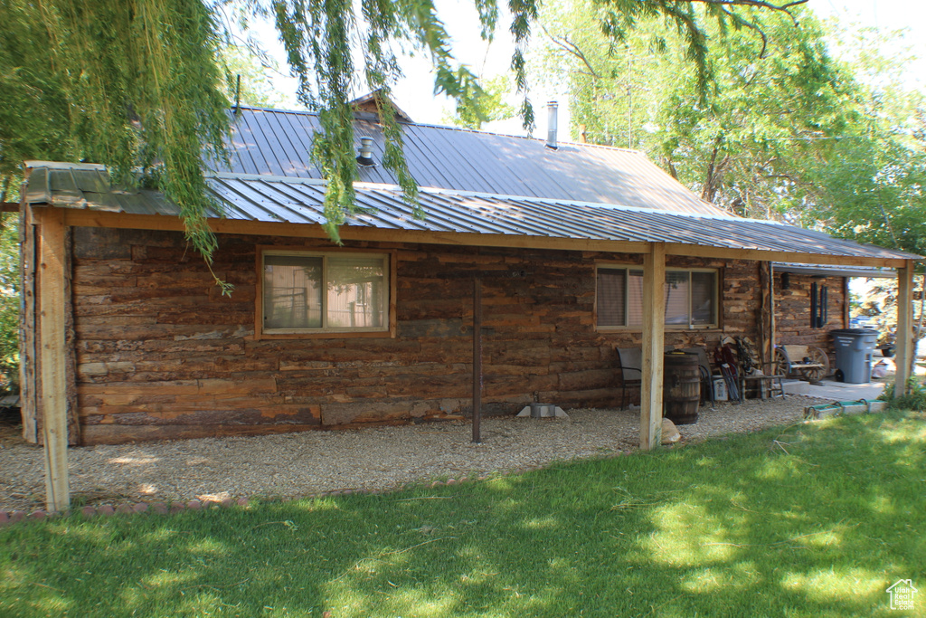 Back of property with a lawn and metal roof