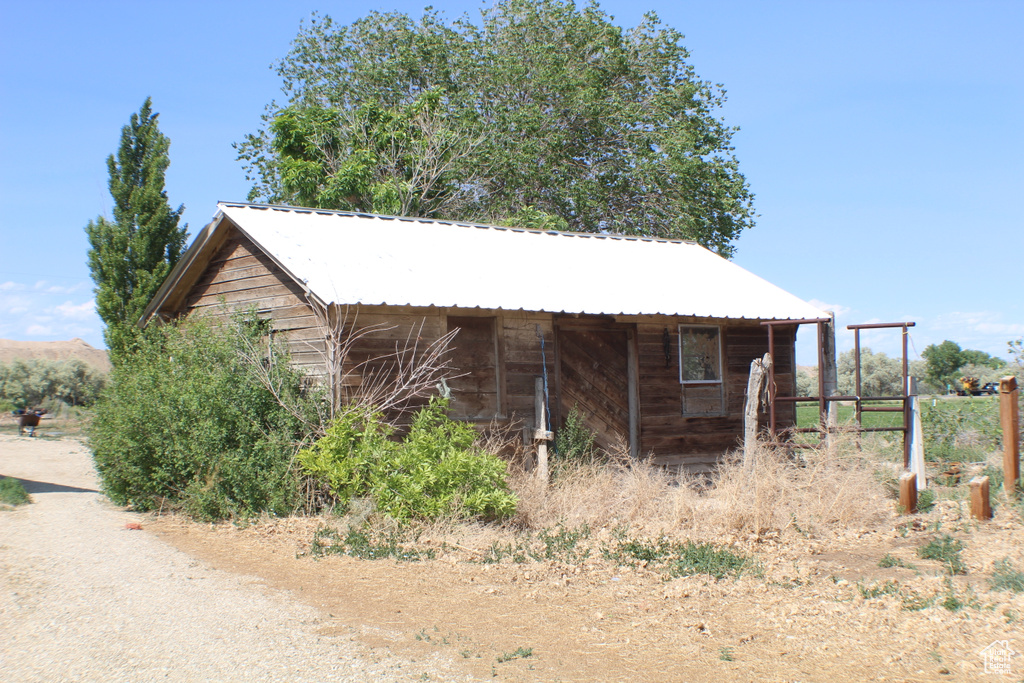 View of side of property featuring metal roof and an outbuilding